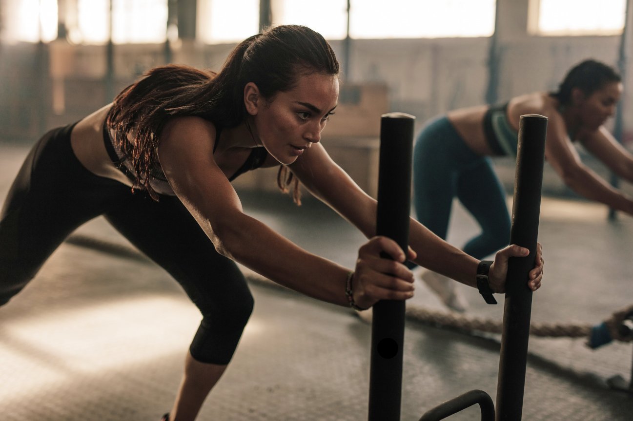 Woman pushing a training sled with focused intensity